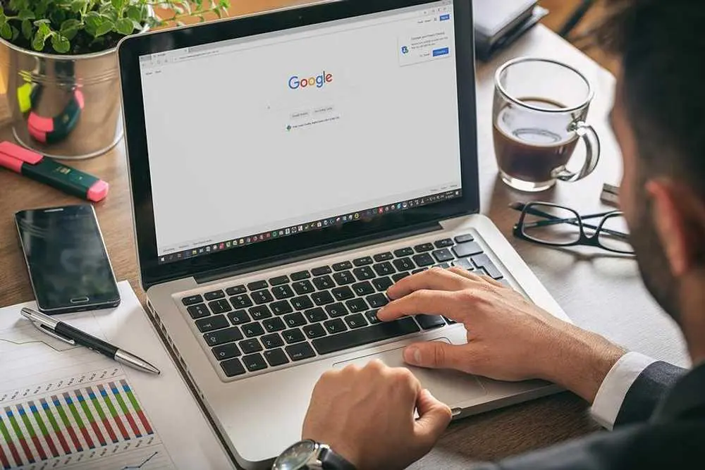 Cara Mendapatkan Klien Baru Tanpa Bergantung Pada Referal Orang mengetik di laptop Google